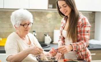 woman helping senior woman to cook